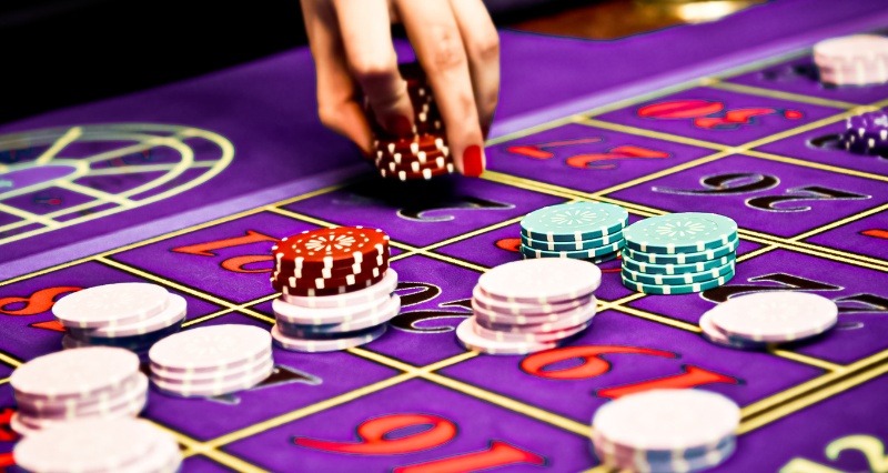 بازیکن در حال قرار دادن چیپ‌ها روی میز شرط‌بندی رولت برای انتخاب نوع شرط