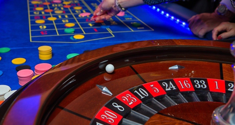 چرخ رولت و بازیکن هنگام قرار دادن شرط روی میز