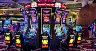 سالن کازینو با دستگاه‌های اسلات و بازیکنان در حال بازی