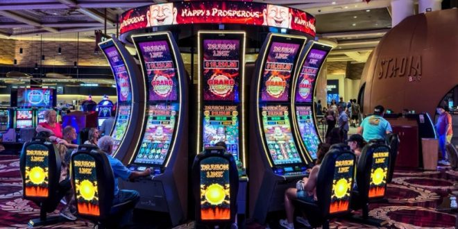 سالن کازینو با دستگاه‌های اسلات و بازیکنان در حال بازی